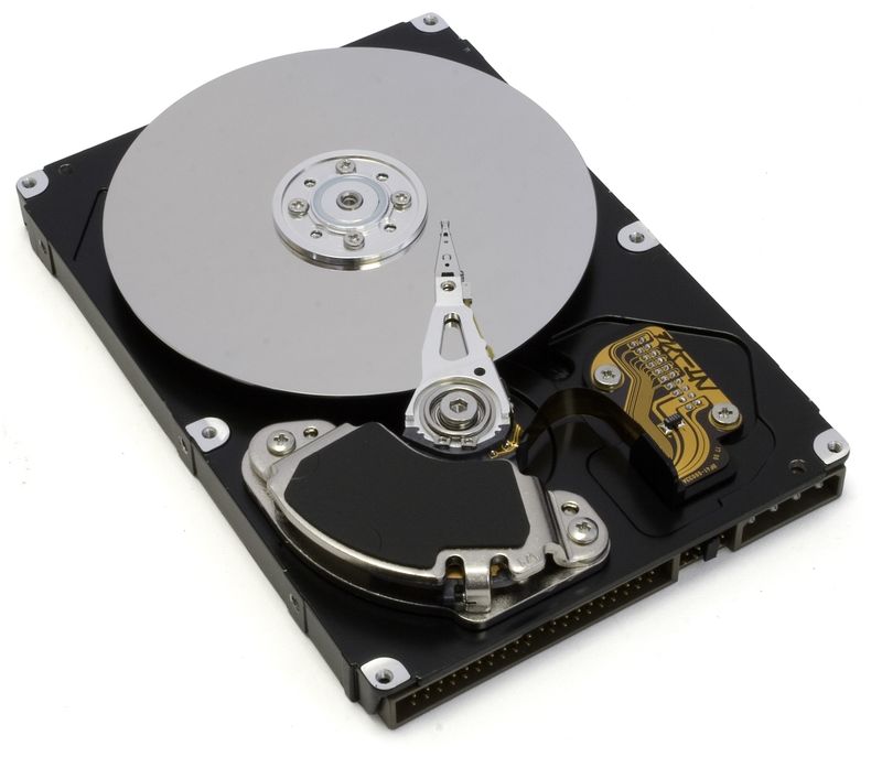 An opened hard drive showing its data platter and read arm