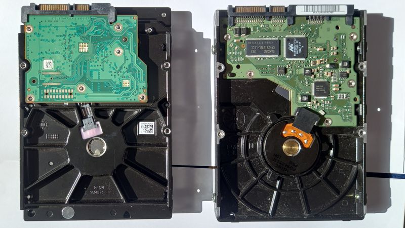 Two hard drives turned over, showing their circuit boards