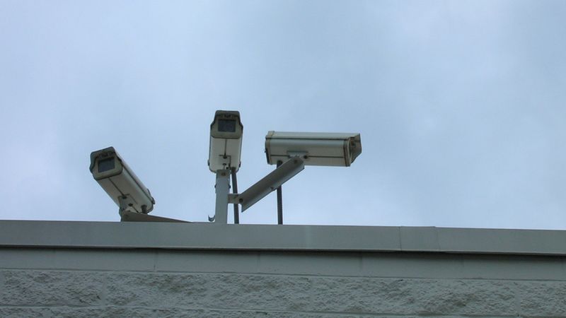 Security cameras mounted on a building roofline